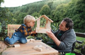 Grandfather and grandson building a custom bird feeder