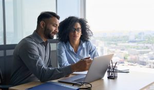 Middle aged couple looking at laptop together and comparing options