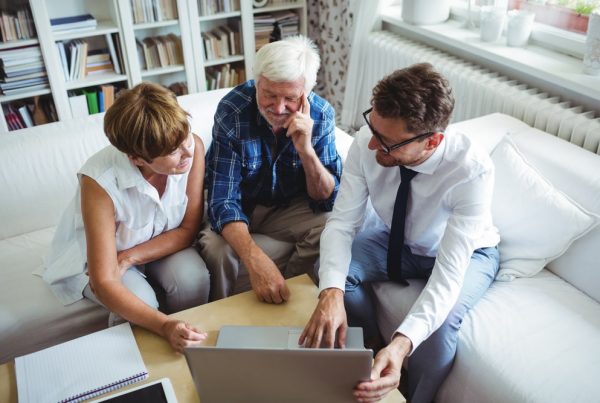 Mature couple sitting down with funeral professional to discuss insurance payment options