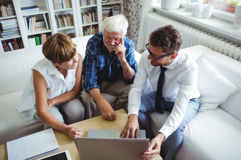 Mature couple sitting down with funeral professional to discuss insurance payment options