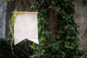 shows a white outdoor flag against a wall of ivy