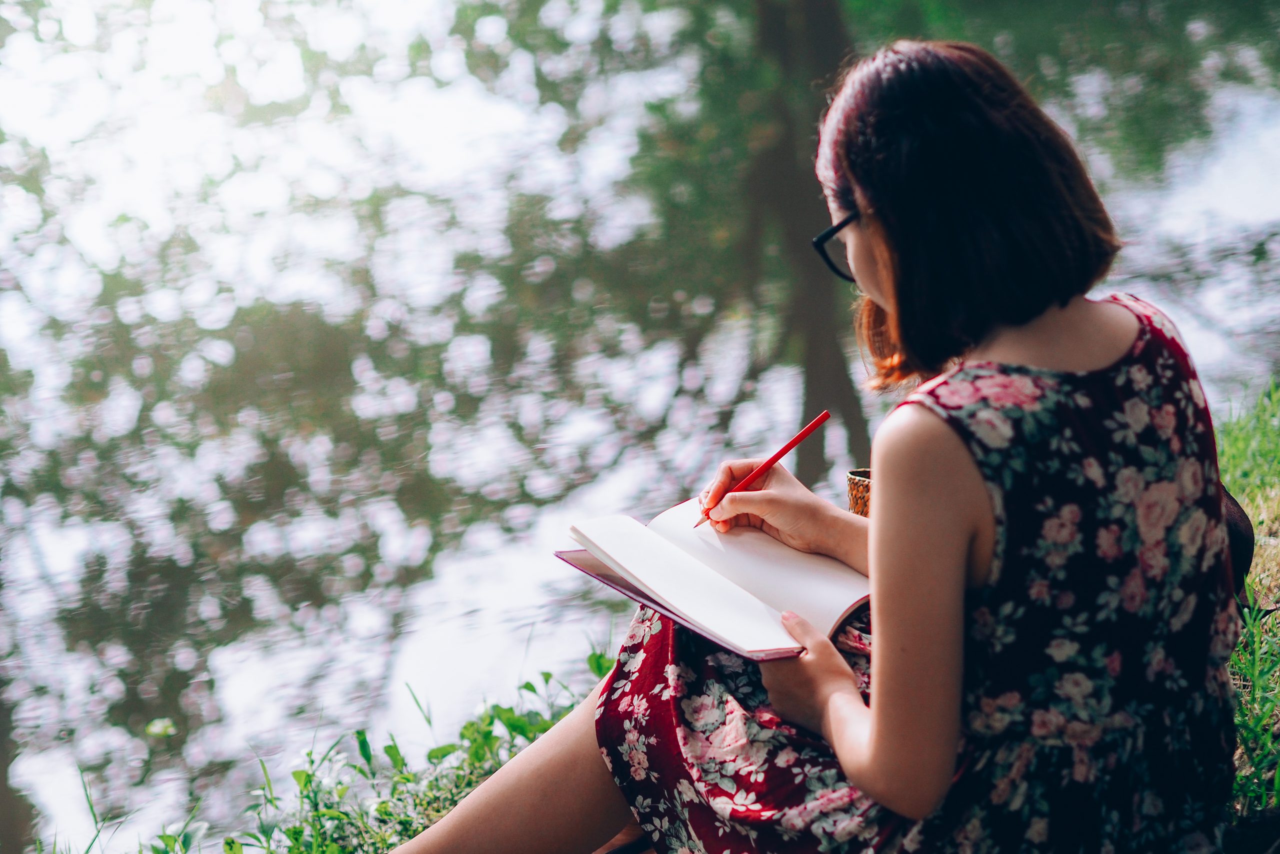 beautiful woman writing into her diary, in the park