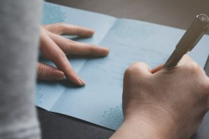 person writing a note in a sympathy card