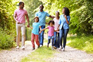 Shows carefree multi-generational family walking outside together and having fun