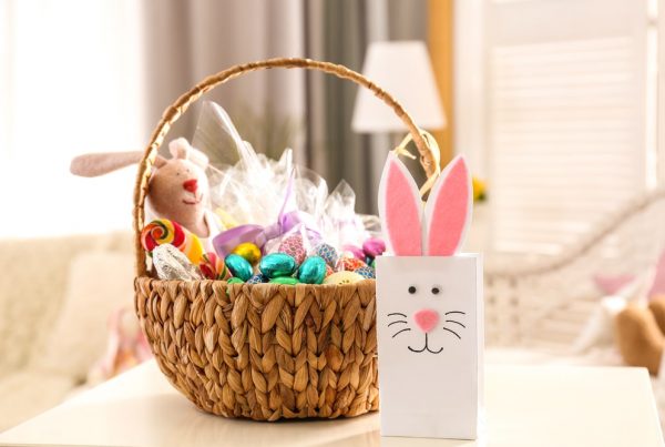 Shows decorated Easter basket with candy, homemade bunny, and stuffed animal