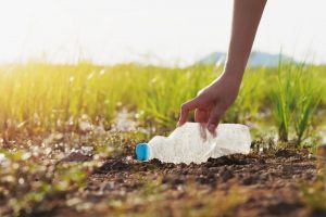 Person picking up an empty water bottle