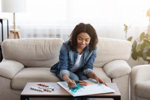 woman sitting on couch as she worked on colorful portrait