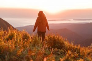 woman standing in a field on a mountain