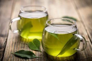 two cups of green tea sitting on wooden table