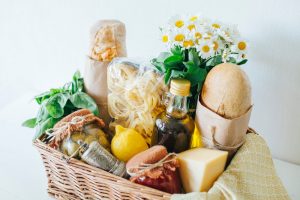 food gift basket with bread, pasta, and daisies