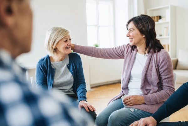 focus on two women attending a grief support group, one older and one younger