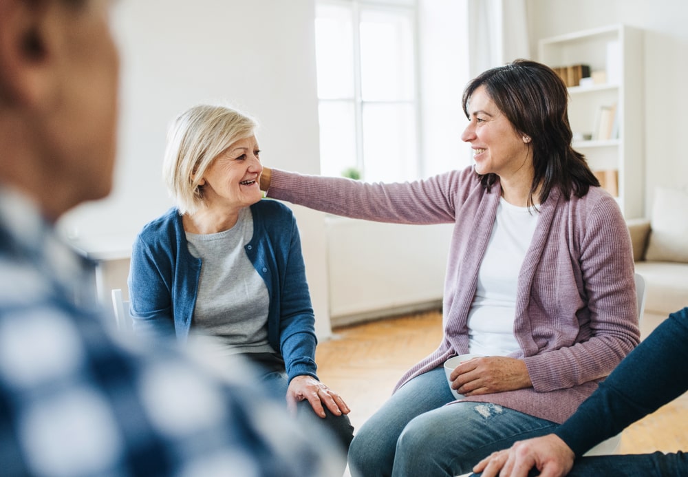 focus on two women attending a grief support group, one older and one younger