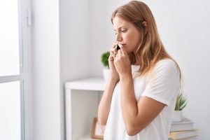 Young woman making phone calls from her home