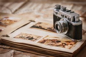 Still of an old camera sitting on photos, representing a photographer's life