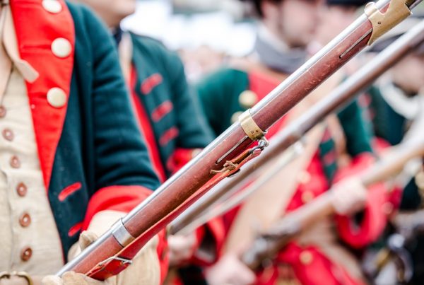 Soldiers dressed in Continental Army uniforms, holding rifles