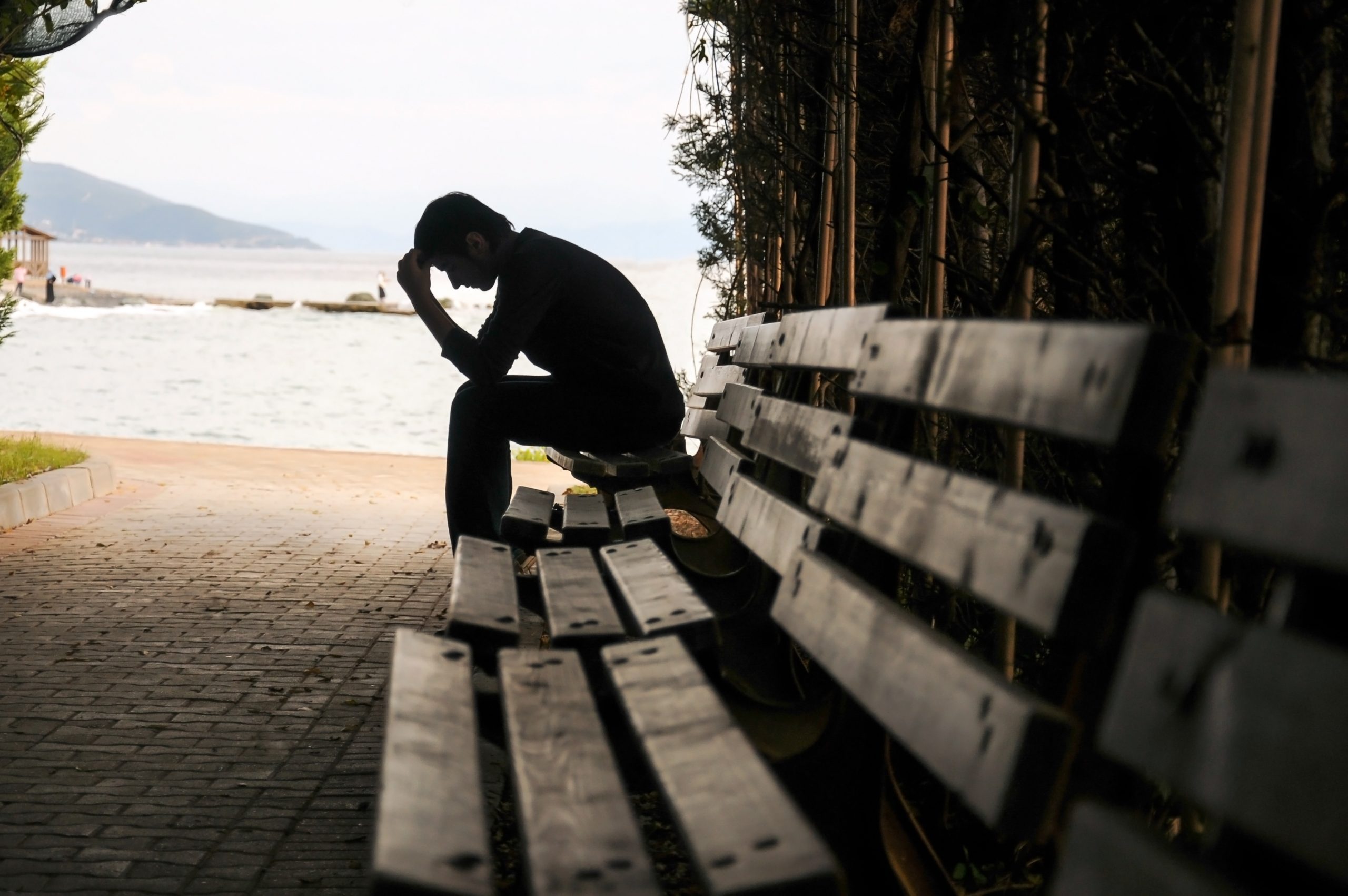 Depressed young man sitting on the bench in tunnel.