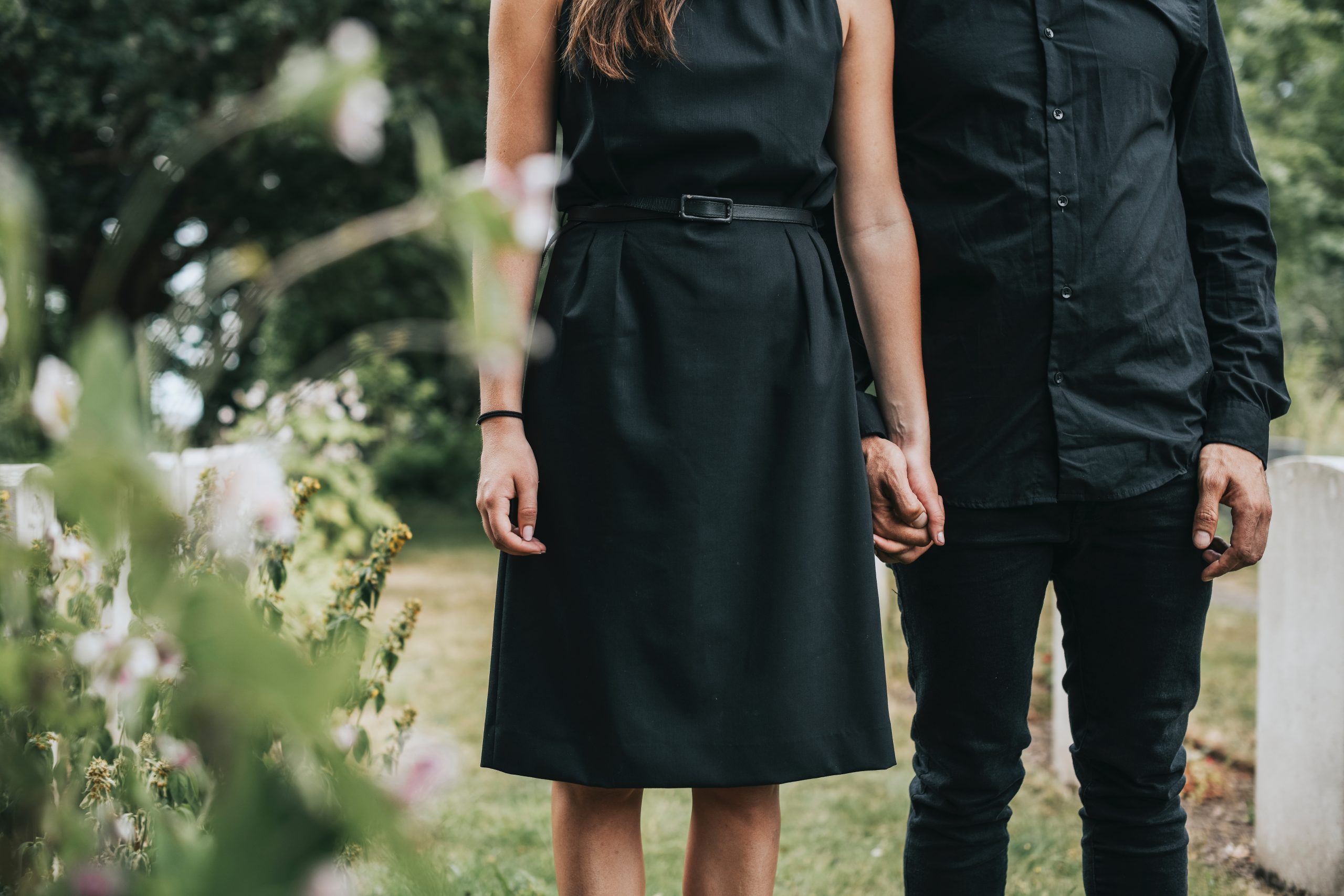 Couple holding hands at a graveyard