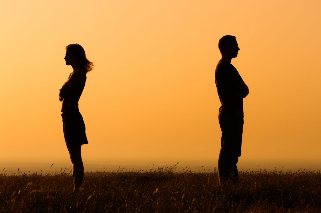 Silhouette of a angry woman and man on each other. Relationship difficulties