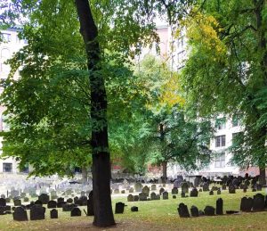 King's Chapel Burying Ground at a distance, with dark and weathered grave markers in the foreground