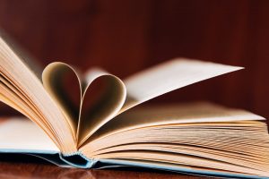 A open book with two pages folded to create a heart in the middle