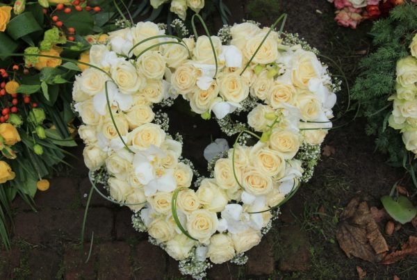 Heart-shaped funeral wreath of white flowers