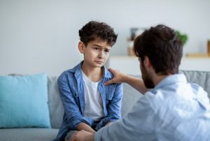 Dad talking face to face with his middle-age son, explaining the suicide of a parent
