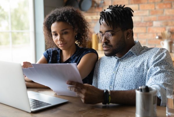 Couple sitting at table at home, reviewing an itemized statement