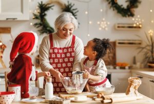 Grandmother in her kitchen, baking Christmas cookies with grandchildren during the holiday