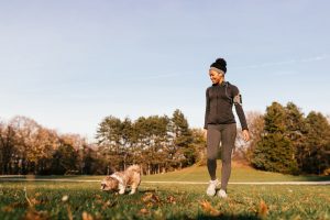 Young woman taking a relaxing walk outside with her dog