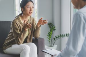 Young woman talking to therapist about her thoughts and feelings