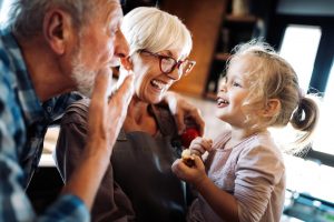 Grandparents laughing with young granddaughter