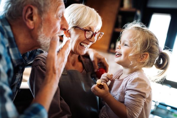 Grandparents laughing with young granddaughter