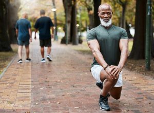 Middle-aged man stretching at the park as he prepares to exercise