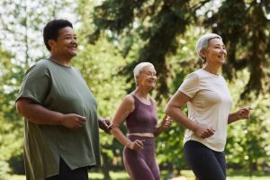 Three older women walking together outside, enjoying time together