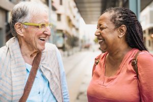 Two elderly friends laughing together outside