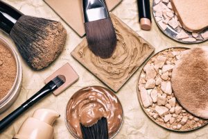 Close-up of makeup brushes, foundations, powders, and concealers