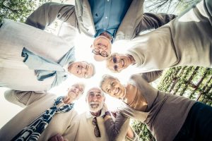 group of elderly friends laughing in a circle