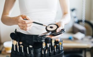 Cosmetologist wearing makeup kit around her waist