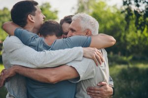 Son and three sons hugging; family close-knit