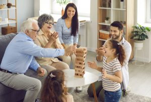 Young family playing a game during a grandparent visit; everyone happy and at peace