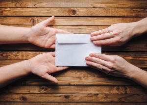 One person giving a closed honorarium envelope to a second person