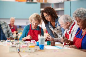 Group of seniors in a painting class with instructor