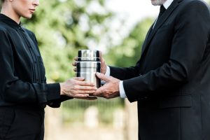 Man and woman holding a silver urn between them