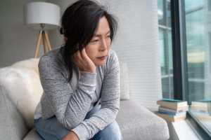 Sad woman sitting on chair at home