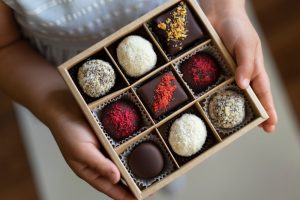 Person holding a box of Valentine's Day truffle chocolates