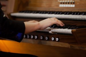 Focus on the hands as a woman plays an organ
