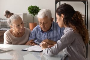 Mature man and woman talking with professional about estate planning or funeral planning