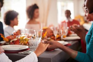 friends holding hands at Thanksgiving