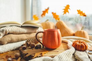 pumpkin mug next to cozy blankets