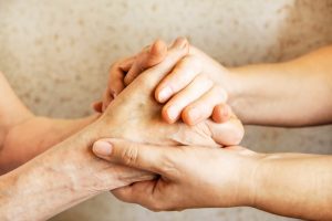 two people holding hands to comfort each other